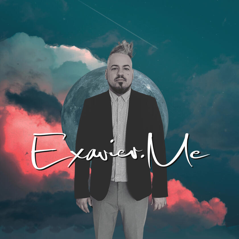 Exavier Me standing in front of a planet, in front of clouds, he wears a fulled button shirt with a blazer and disheveled hair standing and leaning to the side.